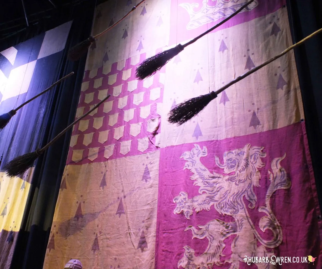 Broomsticks flying in front of a gigantic banner at the Harry Potter studio tour, UK.