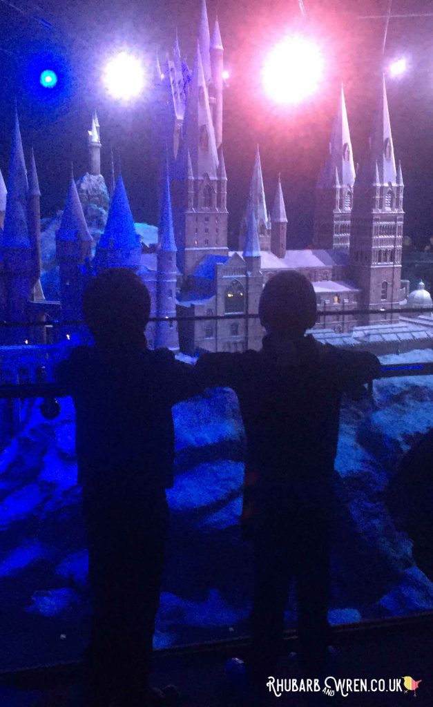 boys watching the 'sunrise' over the Hogwarts model at the Harry Potter studio tour