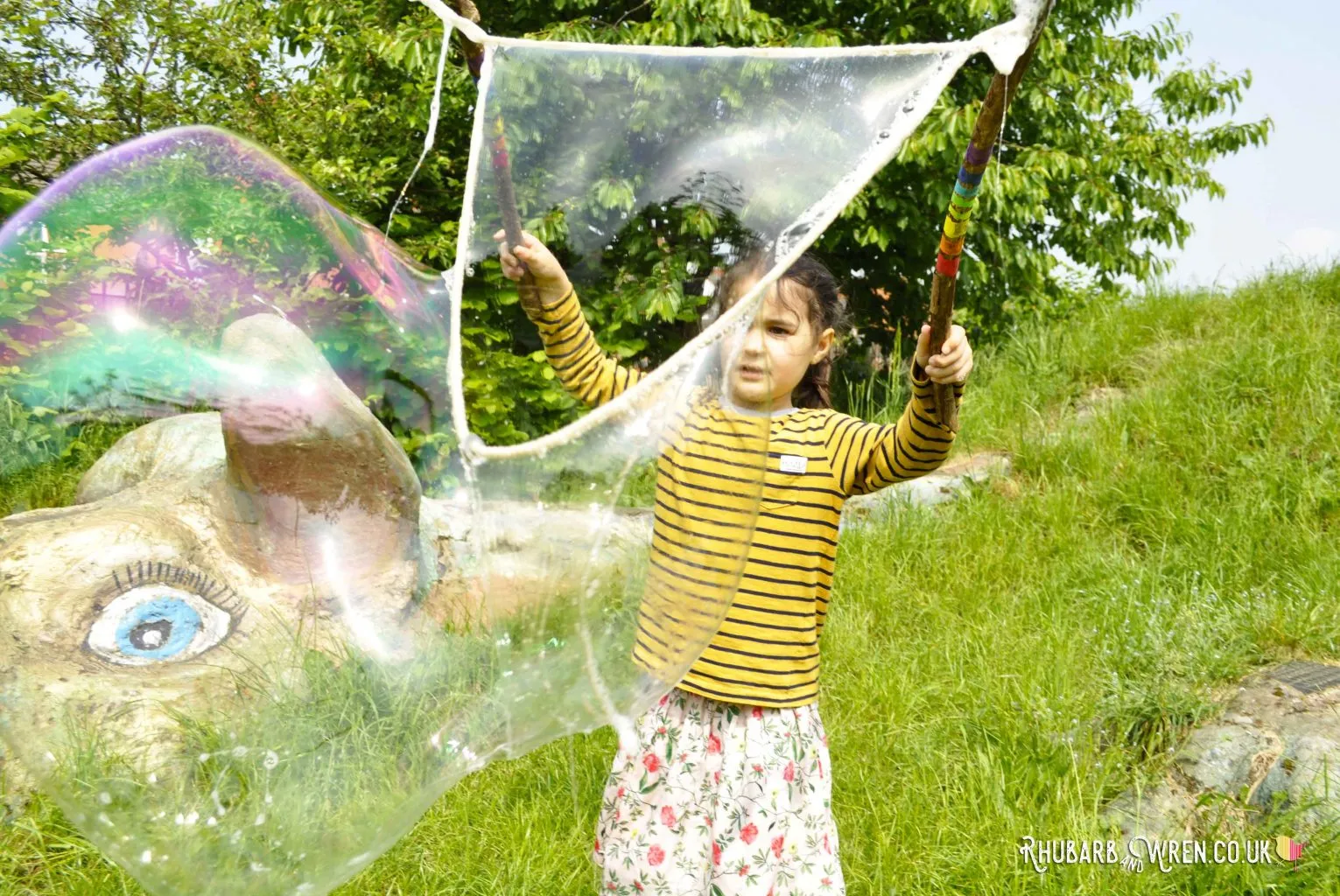 Child making bubbles with home-made giant bubble wand