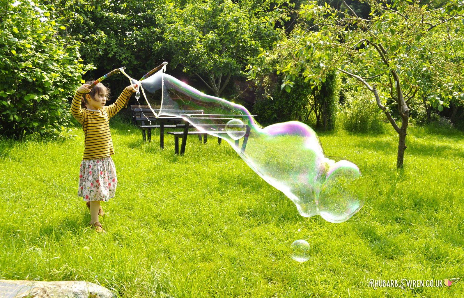 child making giant bubbles with tri-string giant bubble wand