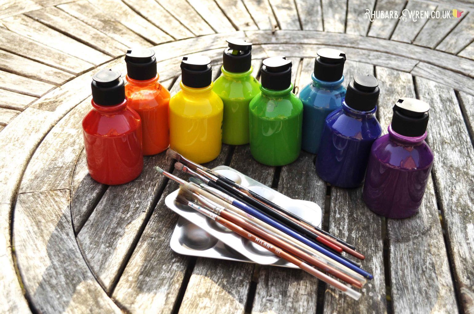 Rainbow shades of paint for decorating a DIY magic wand