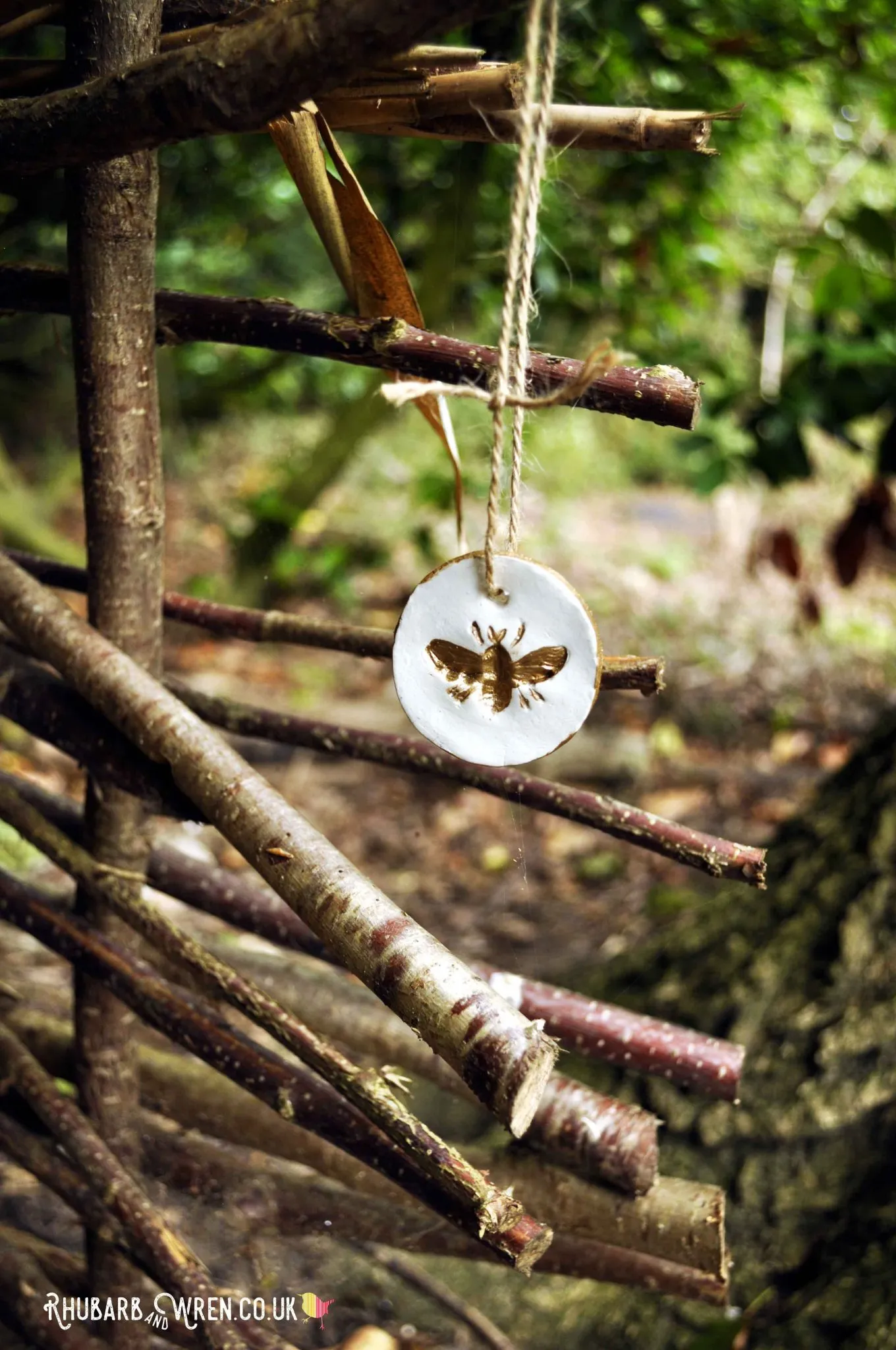 Gold bee pendant for treasure hunt hanging in woods