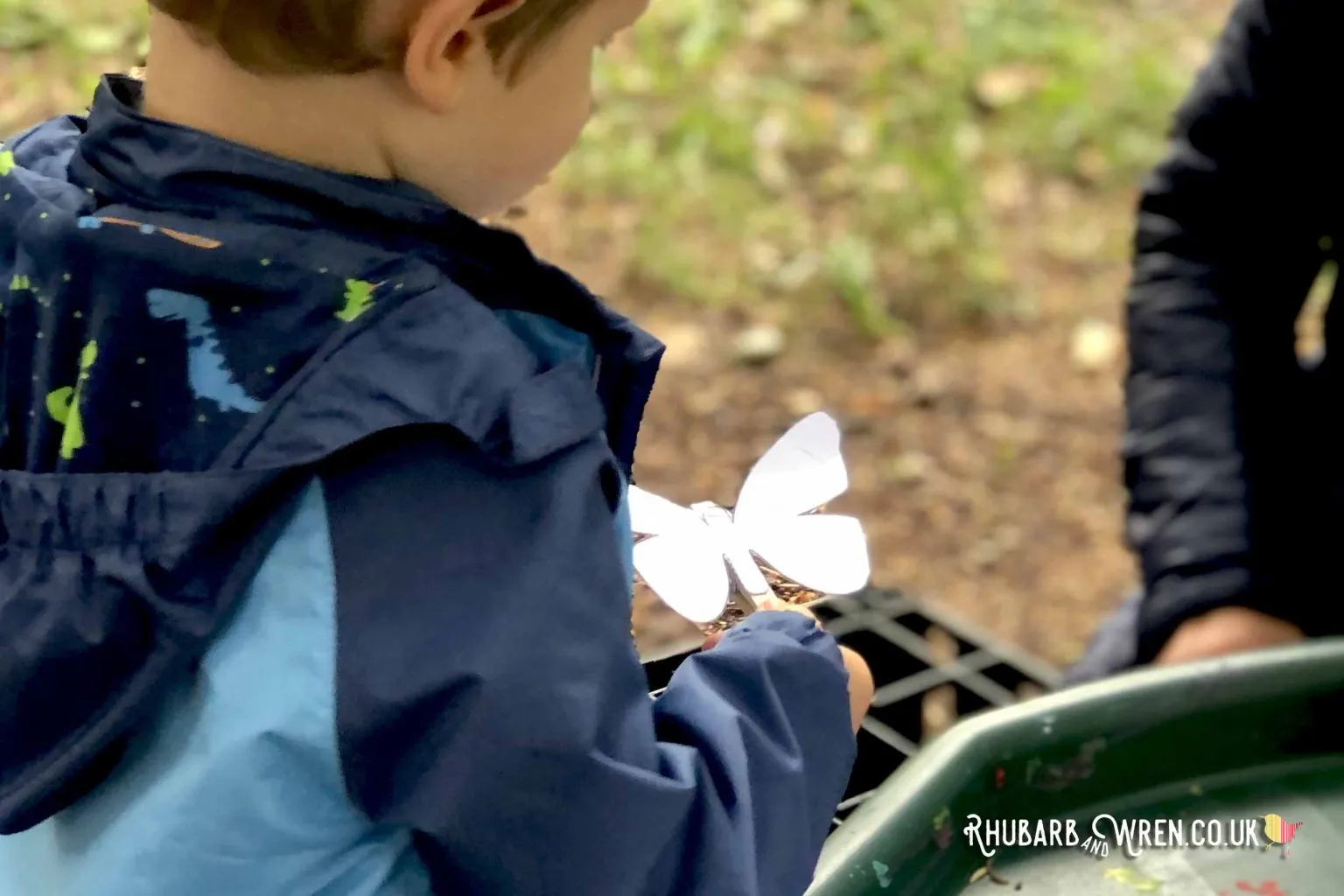 A boy making a butterfly at forest school.