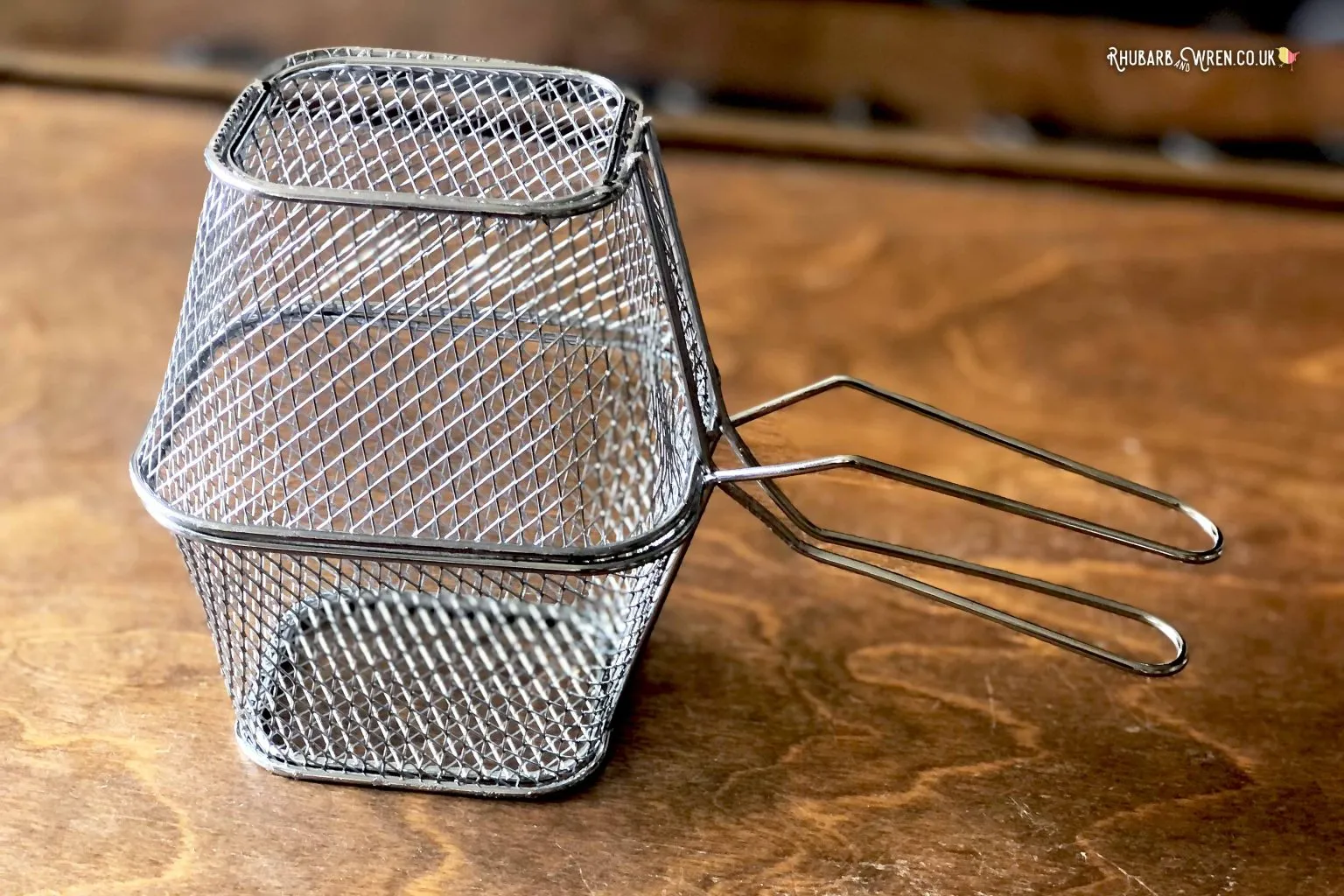 Mini frying baskets being used to make a popcorn pan for a campfire